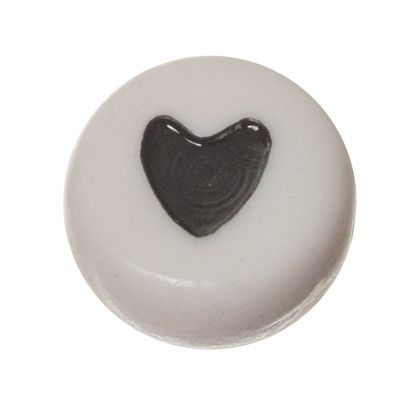 Plastic bead, round disc, 7 x 3.7 mm, white with black heart 