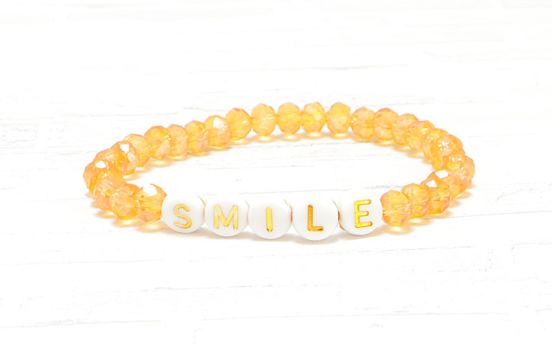 Bracelet avec perles alphabet avec écriture dorée Smile 