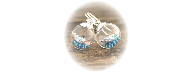 Boucles d'oreilles maritimes avec pendentif bateau en papier dans une boule en verre 