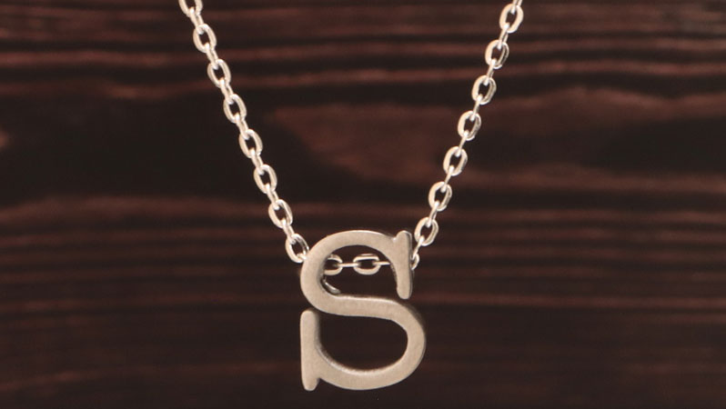 Collier avec perles en forme de lettres monogramme argenté 